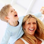Laughing mother holding her little son piggyback, playing together. Laughing mother holding her little son piggyback, playing together.